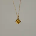 Close-up detail of a square yellow zircon pendant necklace with 18K gold plated finish - November