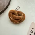 Schattige bruine pluche krakeling sleutelhanger met geborduurd gezichtje voor tas. - Pretzel (kogelketting)