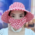 Nahaufnahme eines rot-weiß karierten Sonnenhuts mit integrierter Gesichtsschutzmaske - Gitter Stil / Rot Weiß