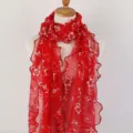 Detailed view of red floral lace scarf featuring elegant ruffle edges and embroidery - Bright Red