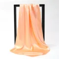 Detailed macro shot of a peach satin square scarf with elegant drape on white background - 90*90cm / Tangerine