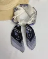 Detail view of a 70cm silk scarf with classic sketch carriage and blue border pattern. - Carriage Black