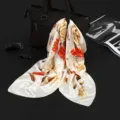 Detailed view of elegant floral print satin square scarf draped over a black handbag - Single Flower Red