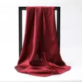 Close-up of burgundy satin square scarf draped over a black display frame - 90*90cm / Burgundy
