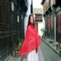 Elegantly styled woman wearing a red embroidered ethnic cotton linen shawl in a traditional alley - 90x180cm / Watermelon red