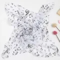 Detailansicht eines leichten weißen Schals mit elegantem schwarzem Noten-Print-Design. - Weiß Schwarze Musiknoten