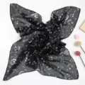 Detailansicht eines eleganten schwarzen Chiffonschals mit weißem Notenmuster-Druck - Schwarz Weiß Floral Musiknoten