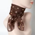 Detailansicht eines braun gepunkteten Seidenschals, an einer Schaufensterpuppe. - Dunkelkaffee Mit Cremeweißen Punkten