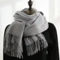Detailed view of the thick gray winter scarf with soft tassels on a mannequin - 200*70cm / Light Gray