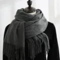 Close-up detail of a dark grey thick winter warm scarf with elegant fringed edges on a mannequin - 200*70cm / Dark Gray