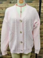 Primer plano de cárdigan de punto rosa con cuello en V, textura jacquard y botones - S / Tops / Rosa