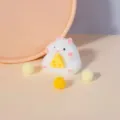 Detailaufnahme eines süßen weißen Hamster-Squishys, der einen kleinen Käse hält - Weißer Hamster