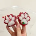 Close-up detail of Christmas cat paw squishy toys in clear bags for stress relief - Santa Claus / Christmas Red Cat Paw