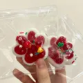 Close-up view of Christmas themed cat paw squishy toy inside clear plastic packaging - Snowflake Bell Style / Christmas White Cat Paw