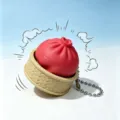 Creative red steamed bun squishy toy keychain in a detailed mini steamer basket. - Red