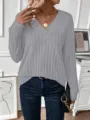 Primo piano di un maglione grigio a coste con scollo a V, jeans blu e gioielli eleganti. - 1XL / Top / Grigio chiaro