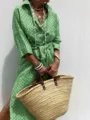 Dettaglio di un abito a camicia verde a motivi da donna con borsa a cesto in paglia. - Taglia S / Vestiti / Verde