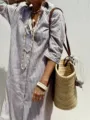 Close-up view of a casual striped linen shirt dress paired with a woven straw bag - Khaki Striped