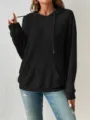Vista ravvicinata di felpa con cappuccio in maglia a coste nera con tasca a marsupio - Taglia S / Top / Nero