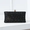 Elegante schwarze Abend-Clutch mit Strasssteinen, goldenem Sternenmuster und Kristallverschluss - Schwarz