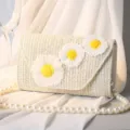 Elegante beige Strohtasche mit Gänseblümchen-Stickerei und einer Perlenkette. - S