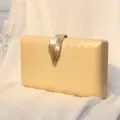 Elegante champagnerfarbene Abendtasche mit goldener Metallblatt-Schließe und Struktur. - Gold