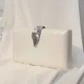 Elegante elfenbeinweiße Abendtasche mit Wellenstruktur und stilvollem silbernem Blattverschluss - Weiß