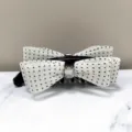Detail view of an elegant white polka dot bow banana hair clip with a sparkly crystal center - White