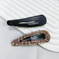 Détail de barrettes noires avec strass champagne sur un présentoir nervuré blanc élégant. - Barrette BB Goutte d'Eau en Strass 3D / Champagne