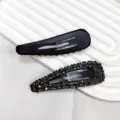 Λεπτομερής προβολή μαύρων κλιπ μαλλιών BB διακοσμημένων με γκρι και χρυσά στρασάκια - 3D Κλιπ BB με Στρας Σταγόνα Νερού / σκούρο γκρι