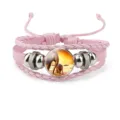 Detailed view of pink multilayer woven bracelet featuring elephant family glass charm - Pink