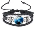 Detailed macro view of black leather bracelet featuring a howling wolf glass cabochon - #02(Forest Moonlight Wolf)