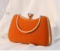 Elegante orangefarbene Samt-Abendtasche mit goldenem Griff und Juwelenverschluss. - Orange