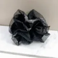 Detailopname van zwarte satijnen scrunchie met fonkelende strassranden op marmer - Zwart