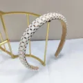 Detailweergave van een elegante haarband met parels en gouden strass-steentjes voor dames - Goud Baguette Zirconia / Bruin