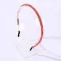 Elegant thin hairband adorned with orange crystal beads on a clear acrylic stand - Red and Champagne