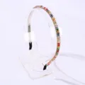 Elegant thin headband with colorful crystal beads on a clear acrylic display stand - Colorful