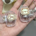 Close-up detail of cute cartoon cat and fish plastic toothbrush protector clips for travel - DIY Sticker Style / One Cat and One Fish Combo