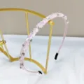 Close-up of a high-end handmade pink crystal rhinestone headband on an elegant gold stand - Thin Handmade Beaded Headband / Pink