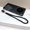 Vue détaillée d'une dragonne de téléphone de luxe en strass noirs avec anneau métal - Noir