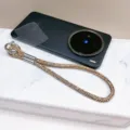 Vue détaillée d'une dragonne de téléphone en strass de luxe sur une surface en marbre - Champagne