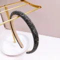 Détail d'un serre-tête luxueux orné de strass noirs sur un support doré - Noir Fusil