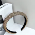 Macro detail of luxury sparkling gold rhinestone padded headband for formal evening wear - Brown Diamond