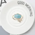 Detailed macro view of a light blue oil-drop mask brooch with sparkling rhinestones - Blue
