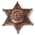 Macro view of a classic bronze six-point star sheriff badge with embossed sheriff text - Copper