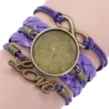 Close-up of handmade purple multi-layer braided bracelet with round bezel and Love charm - Purple