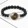 Detail of time gem bracelet featuring gold Arabic calligraphy on black bead band - Black