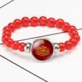 Red beaded elastic bracelet with glass cabochon featuring gold Arabic calligraphy design - Red
