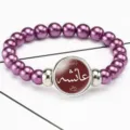 Detailed view of purple pearl elastic bracelet with Arabic Aisha script time gem pendant - Purple