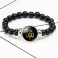 Macro detail of black beaded stretch bracelet with gold Allah Islamic calligraphy - Black